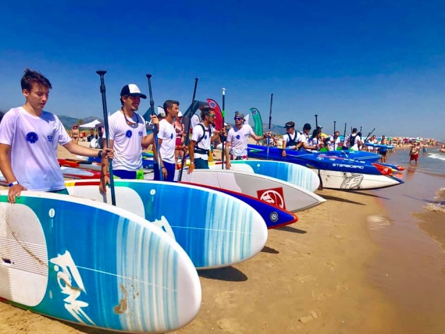  在甘迪亚海滩岸边使用 SUP 冲浪板 