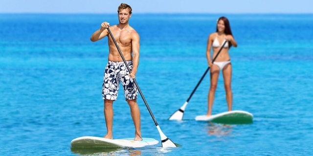 Couples explorant la mer avec la planche SUP 