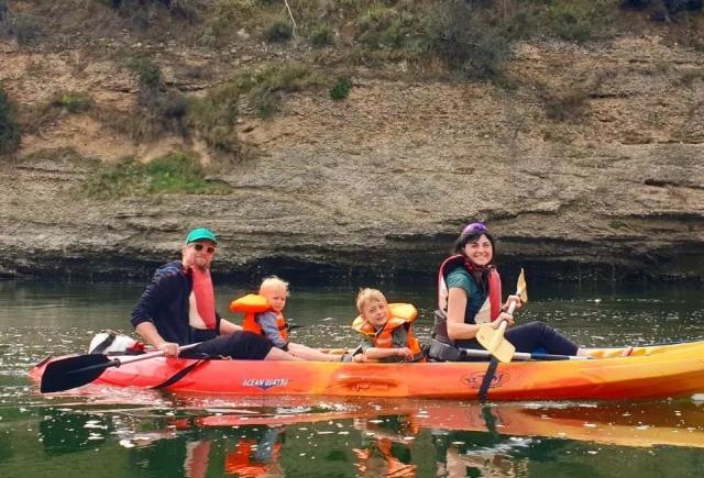 Un kayak ocupado por una familia y sus dos hijos