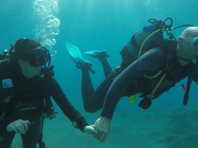  Hand in Hand mit dem Tauchlehrer