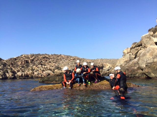 Subidos a una roca en el coasteering