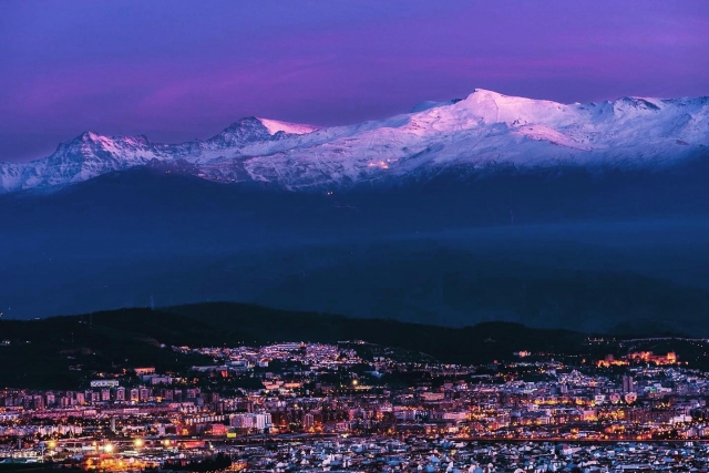  Una maestosa vista panoramica della Sierra Nevada con lo snowboard città ai tuoi piedi di notte