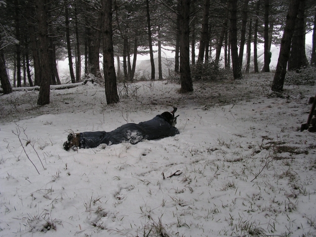 Jugador de paintball tumbado sobre la nieve