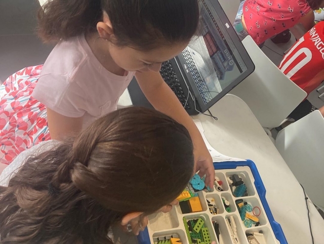 Un par de niños mirando atentamenle algunas pequeñas piezas de enorme utilidad