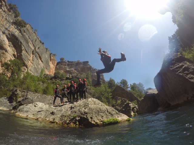  Jumping from a rock into a pool of crystal clear waters 