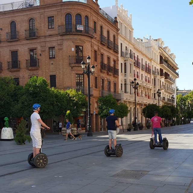  Deux utilisateurs suivent un de nos guides dans les rues de Séville