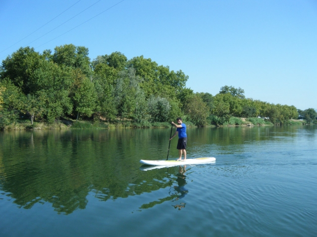 Remando en tabla de sup en la ribera