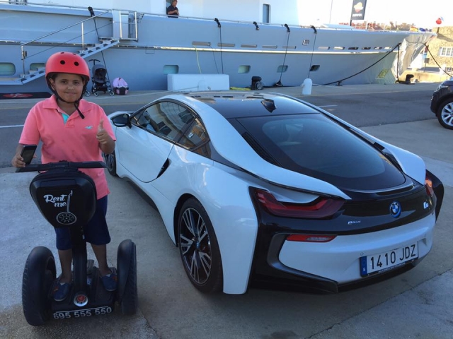  Jeune homme en segway posant à côté d'une BMW 