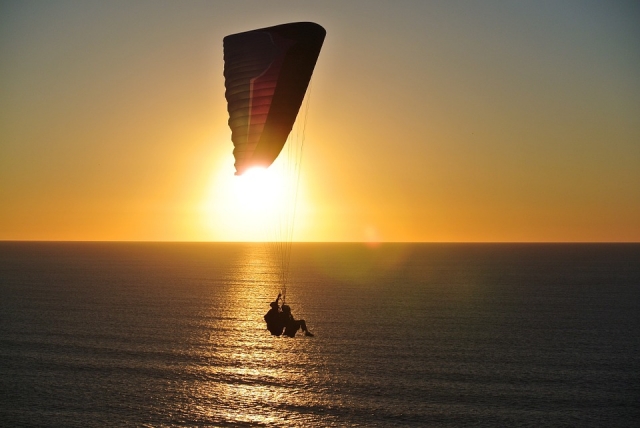 Gleitschirmfliegen bei Sonnenuntergang 