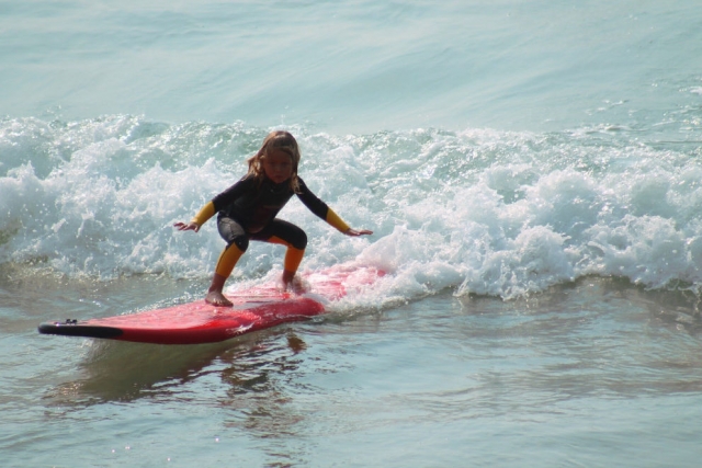 Niño aprendiendo a surfear
