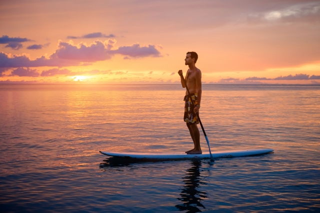 Remando al atardecer sobre la tabla de sup