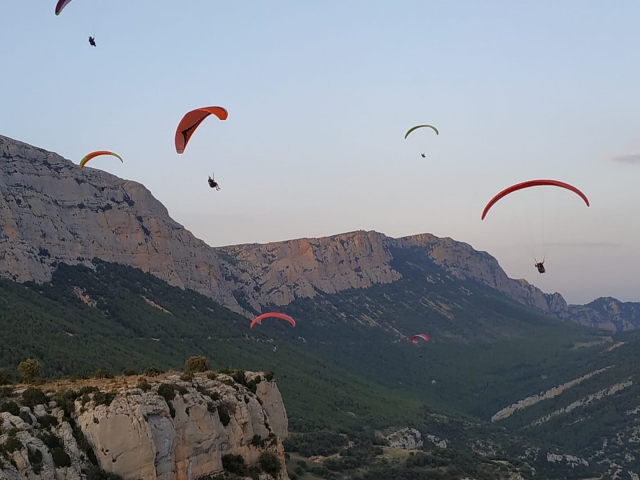  Paraglider im Flug zwischen den Bergen 
