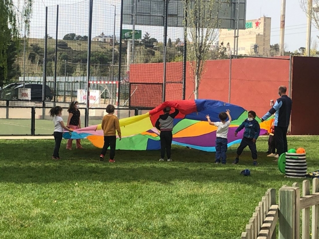  孩子们在草地上铺上不同颜色的防水布 