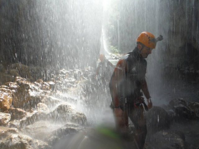 Bajo la cortina de agua de la cascada en la Higuera