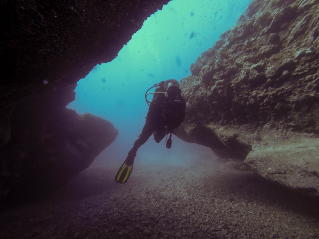  Diver between rocks at the bottom of the sea 