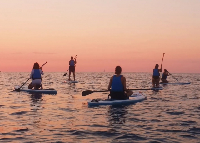Gruppo di cinque persone paddlesurf 