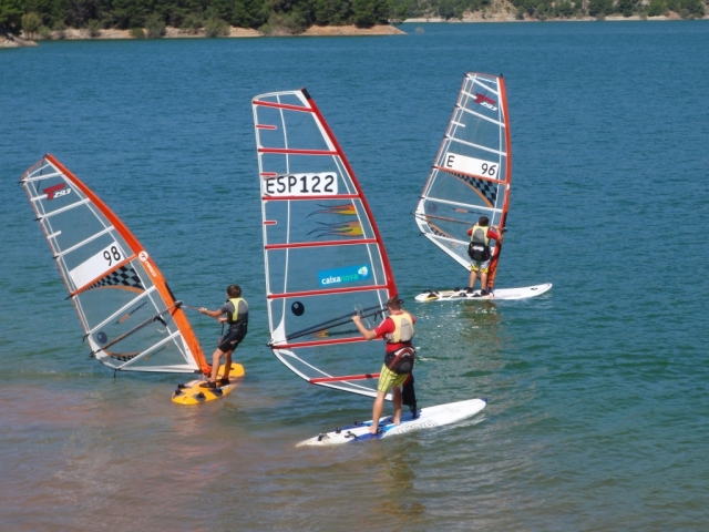 Tres personas haciendo windsurf