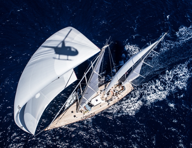  Hélicoptère reflété dans la voile du bateau