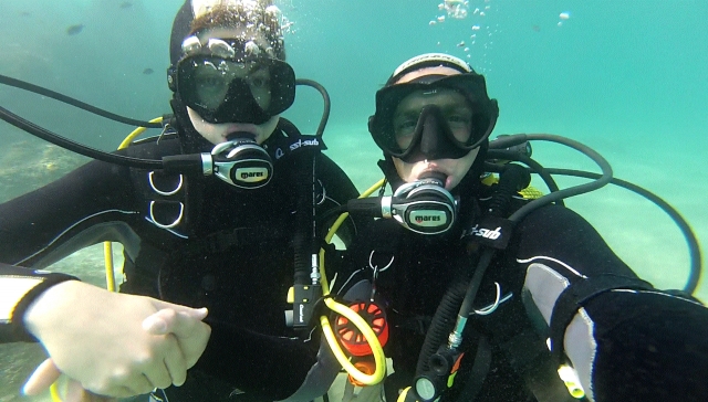 Instructor guiando a alumno en bautismo de buceo
