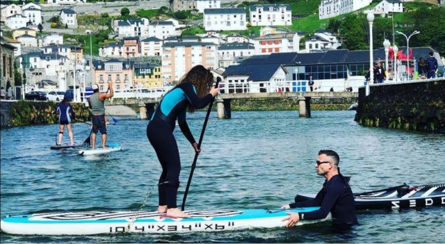 Subida a la tabla de SUP junto al instructor