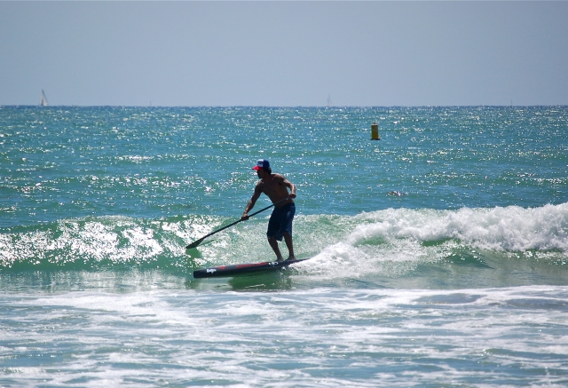 Tomando ola con tabla de SUP Maspalomas
