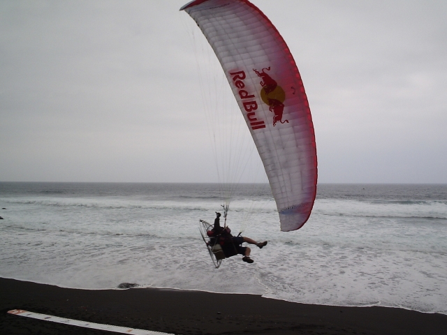 Paramotor aterrizando en la playa