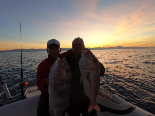  Au coucher du soleil avec les prises dans le bateau
