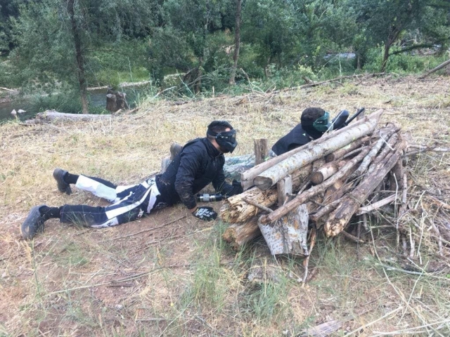 Agazpados tras los troncos en la partida de paintball