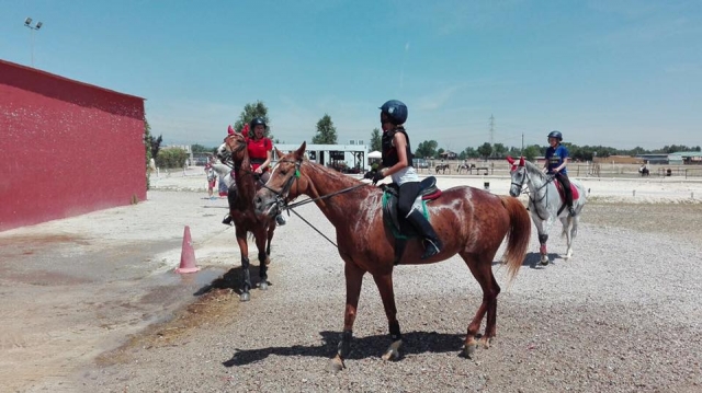 Alumnos de equitación en la pista