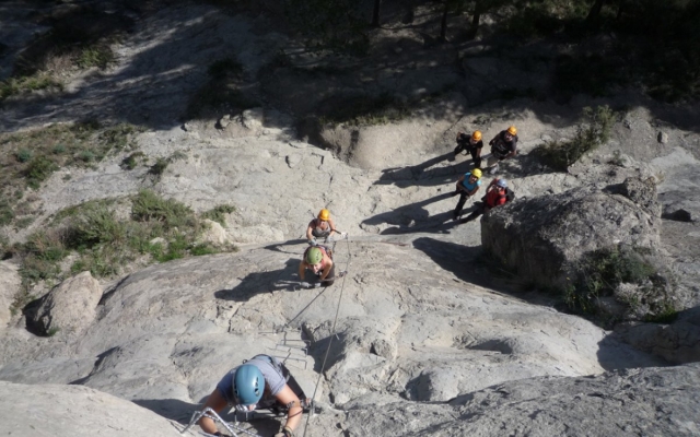 Escalando la montaña en una vía ferrata con amigos