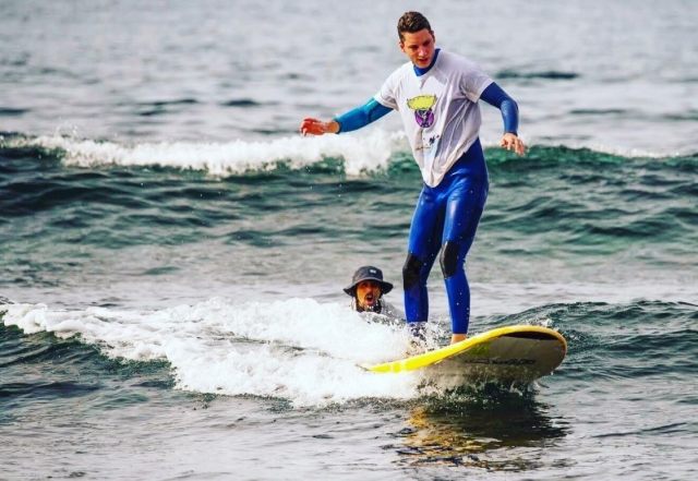 En pie sobre la tabla de surf junto al monitor