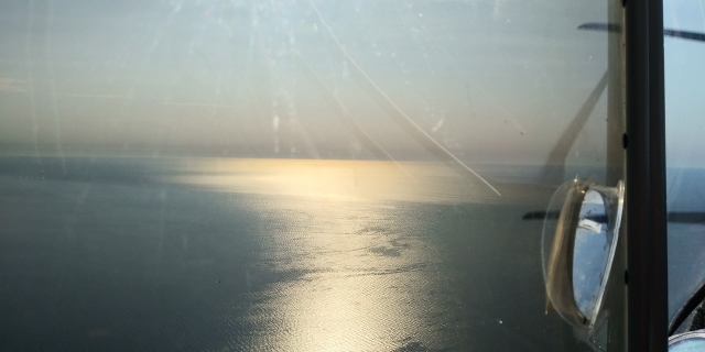 Riflesso del sole nel mare sotto il piccolo aereo 