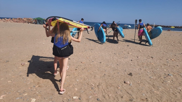 Con el material de surf en la playa