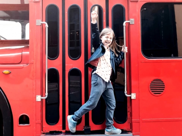 Niña agarrada al autobús