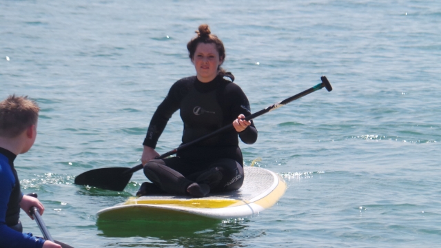 Sentado em uma prancha de SUP