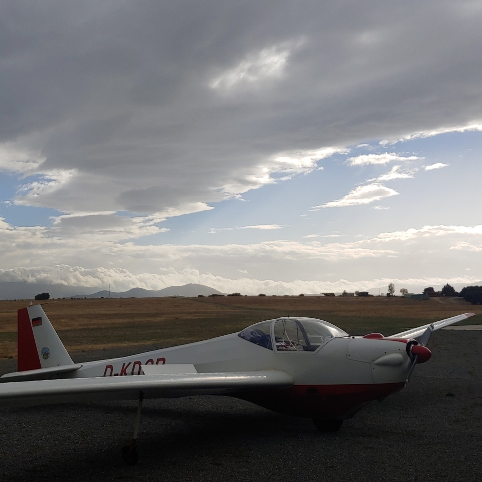 Un planeador parado con un fondo de nubes