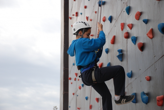 Un niño pequeño demostrando su valía en esta pared vertical