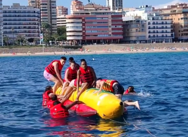  Group of friends having fun on the banana boat 