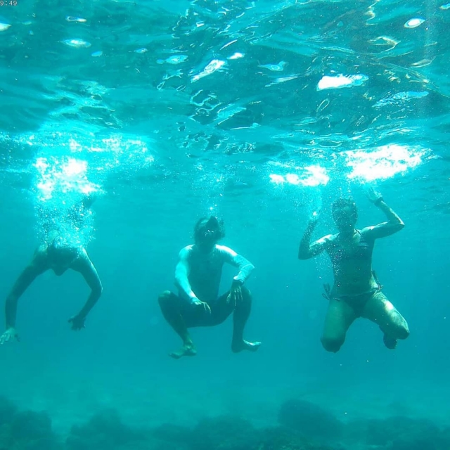  Três usuários submergem na água depois de fazer uma parada durante sua jornada
