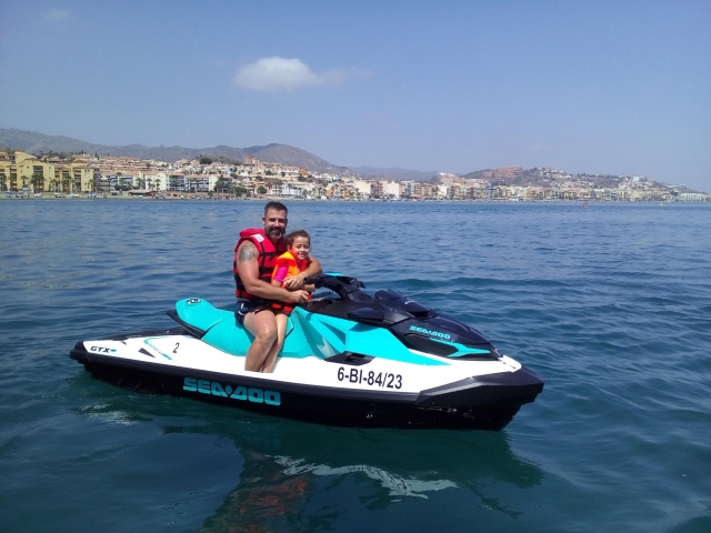 Padre e hija disfrutando de las motos de agua