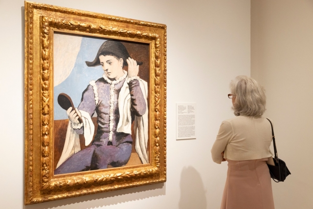 Mujer viendo el cuadro de Arlequín con espejo