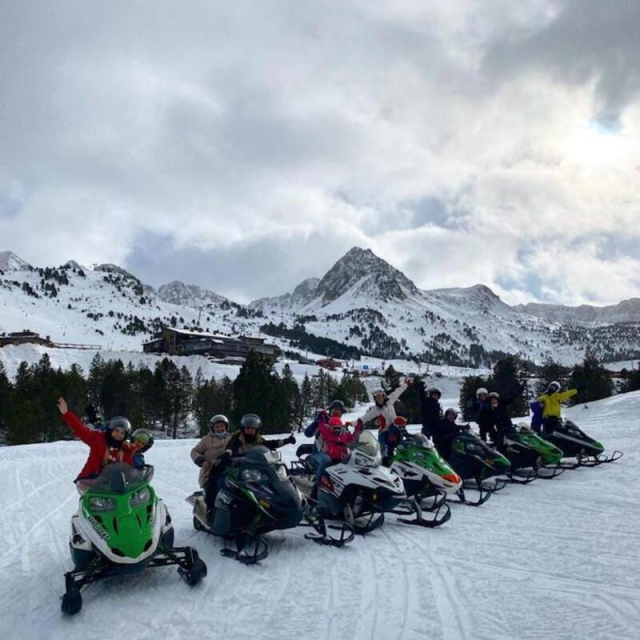En moto de nieve frente a las cumbres
