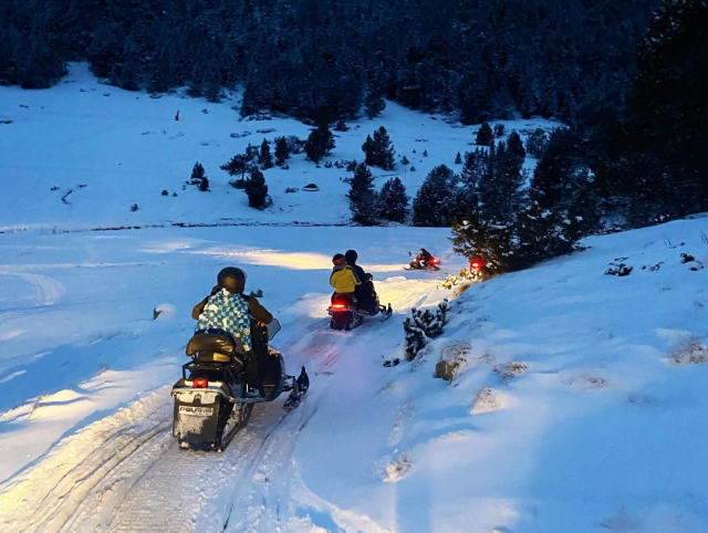 Ruta en moto de nieve con la última luz