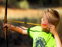  Young archer shooting towards the target 