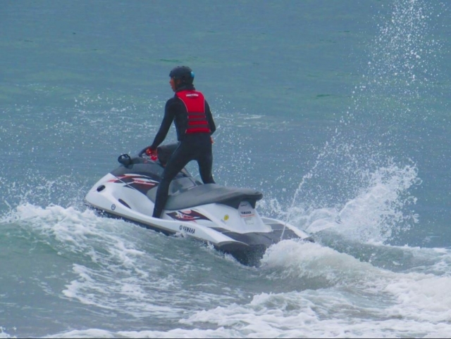 De pie con casco en la moto de agua