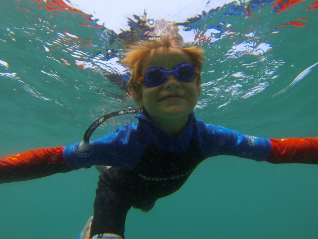 nino ve el fondo del mar haciendo snorkel