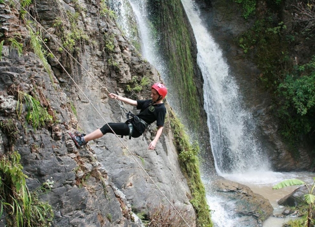 Sujetandose a la cuerda con una mano