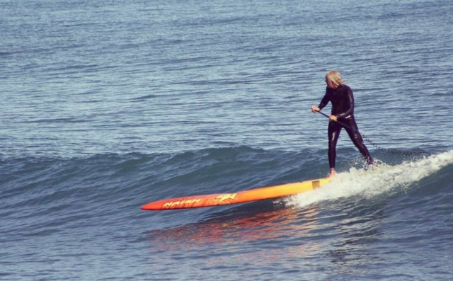 Sobre la ola con la tabla de SUP