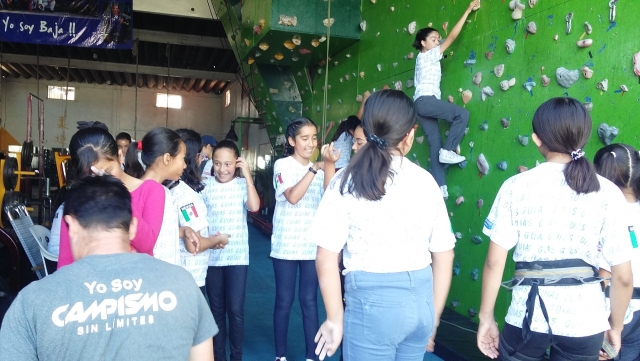 Jóvenes escalando en rocódromo