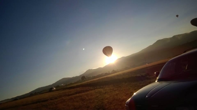 Globo volando con la salida del sol